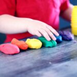 child lining up coloured balls of clay