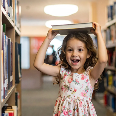 Child holding book in library 