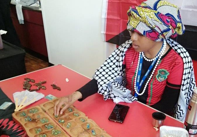 People playing a traditional game of mancala.