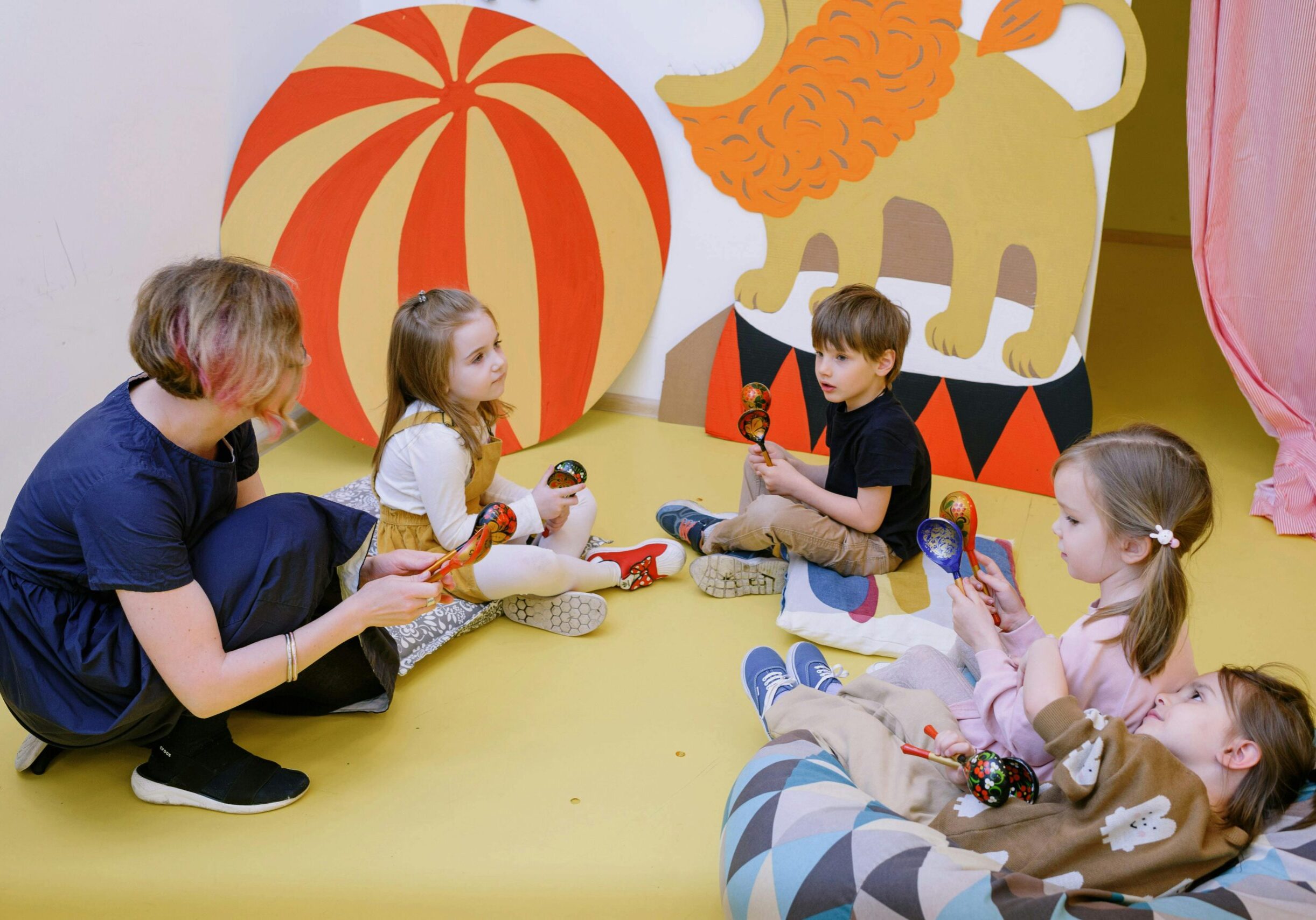 Children and a teacher playing simple instruments and signing